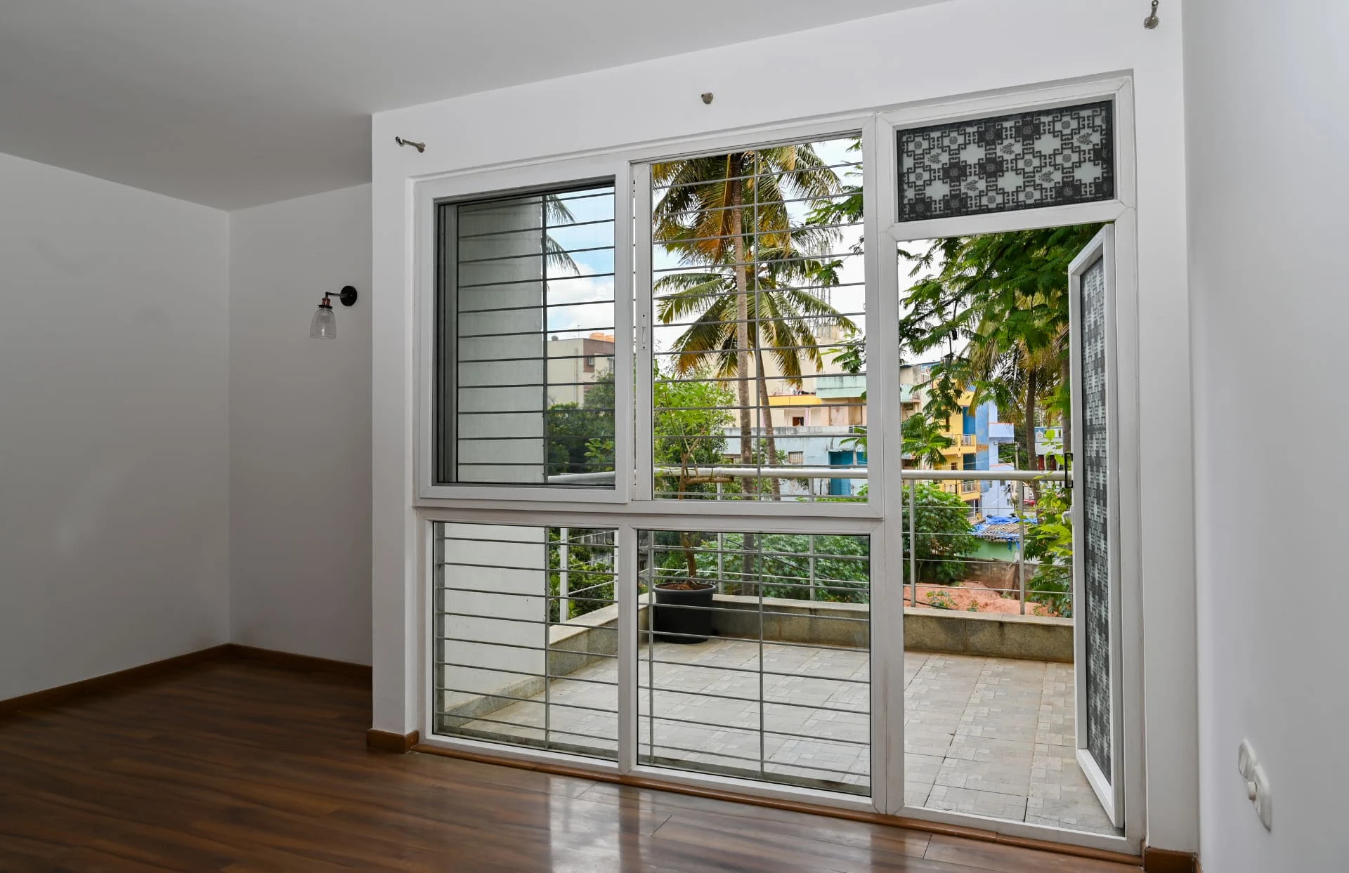 Bedroom opening through full-height glazing onto a private terrace, Prestige Laughing Waters luxury villa for rent, Whitefield, Bangalore