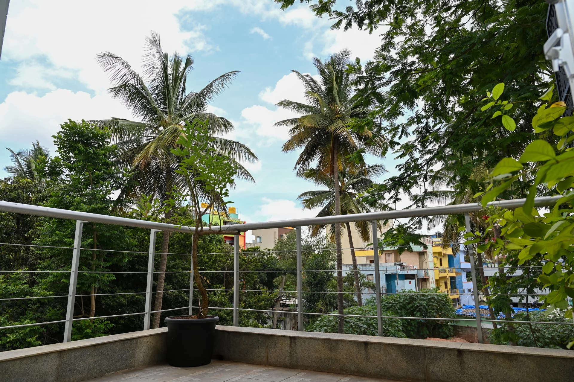 Private terrace looking over palms and the tree-filled layout, Prestige Laughing Waters luxury villa for rent, Whitefield, Bangalore