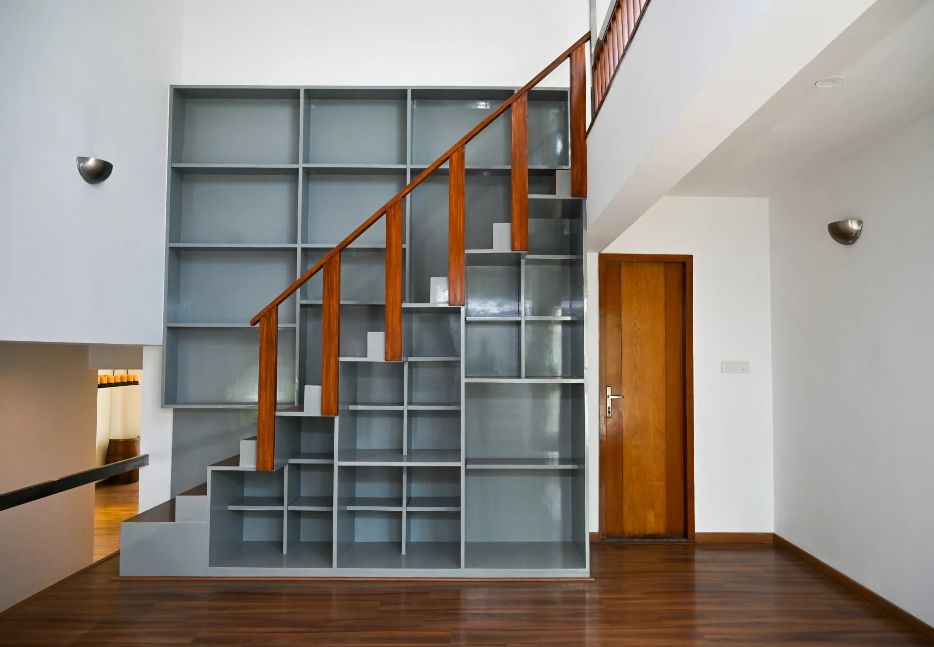 Second villa staircase rising beside built-in shelving, Laughing Waters twin villas for sale, Whitefield, Bengaluru